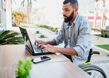 Man in wheelchair using laptop