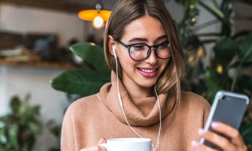 lady looking at smartphone with earphones in