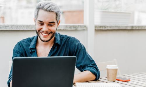 smiling man working on laptop