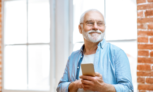 Middle aged man in casual clothing holding a phone